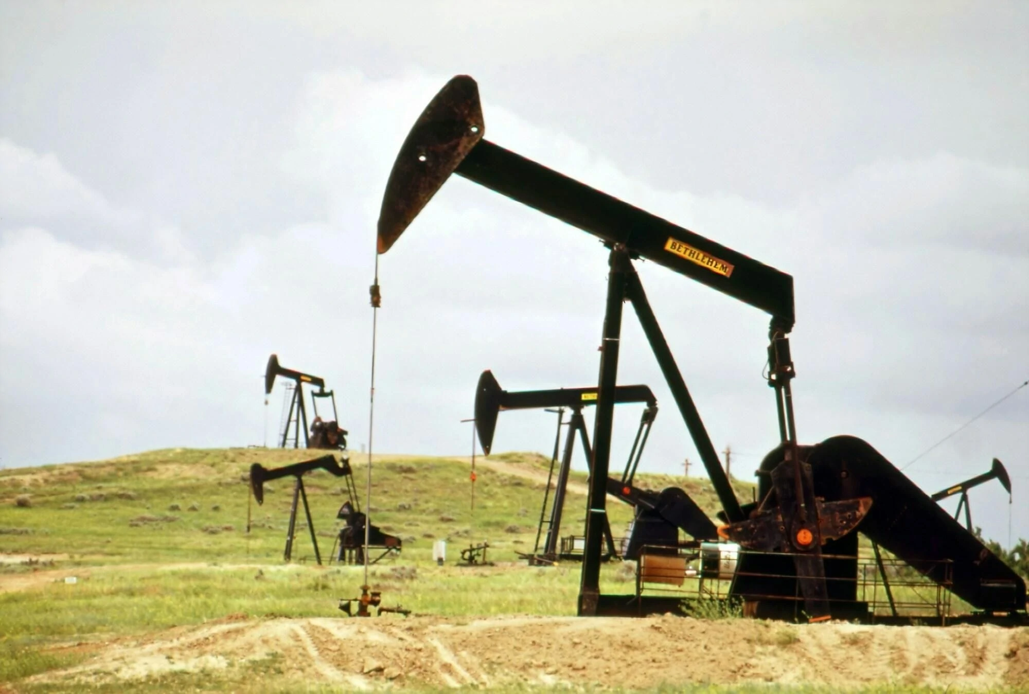 Landman services field operations services. Pumpjack on open Land representing title research and land Services.